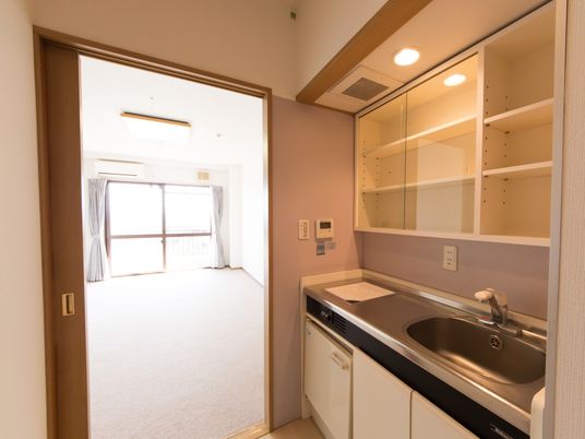 居室を入ってすぐ右手にIHキッチンがある。収納スペースが用意されており、小さな冷蔵庫も完備されている。