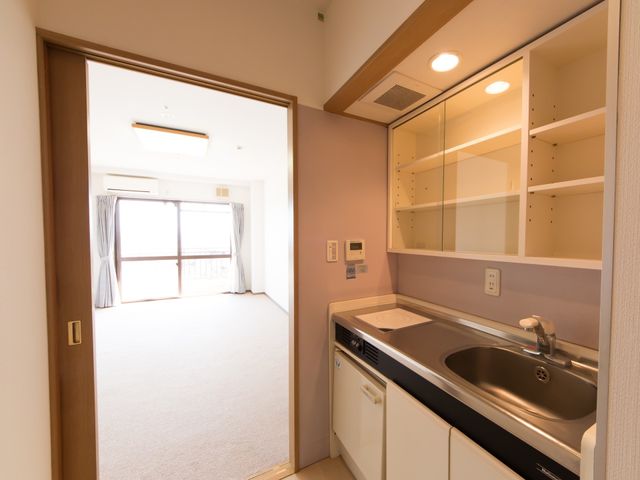 居室のキッチンとリビング ミニキッチン ゆとりある居室には、日常生活をサポートするキッチンが備わり、窓から自然光が差し込んでいます。
