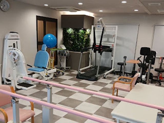 機能訓練器具が並ぶ室内 機能訓練室   運動器具や歩行練習用の設備が整った明るい空間です。介護のお仕事では、利用者さまの体力づくりを支える場面をイメージしやすいです。