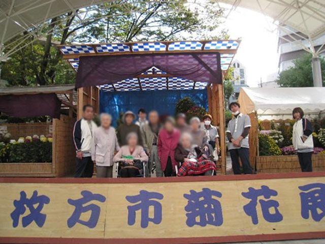 花の展示会の様子 中庭 介護施設の利用者が花の展示会を楽しんでいます。自然に囲まれた穏やかなひとときです。