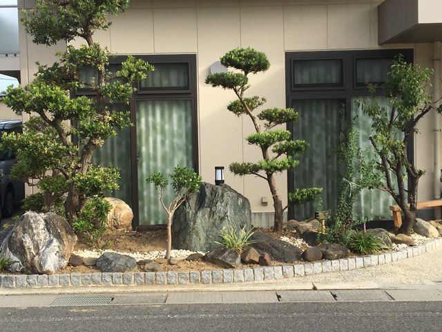 和風の庭と建物外観 庭   手入れの行き届いた和風の庭があり、石や植栽が落ち着いた雰囲気をつくっています。窓越しに自然を感じられる点が、働く環境の魅力です。