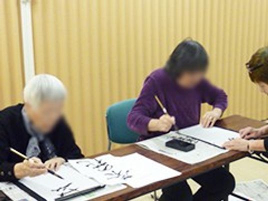 書道をする高齢の方々の様子の居室