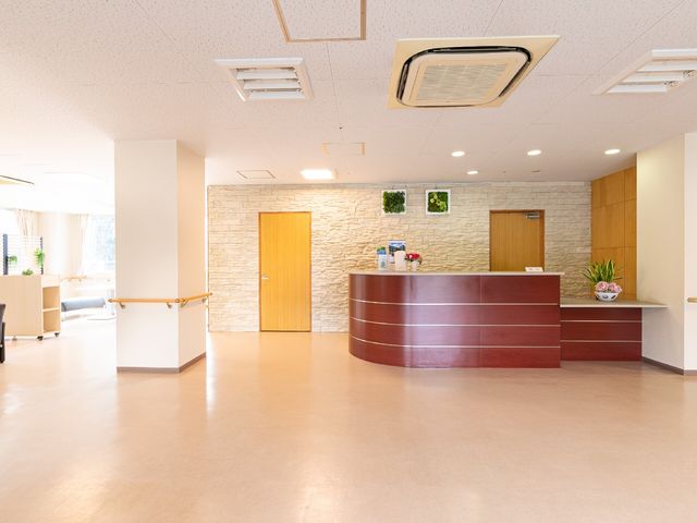 明るい受付ロビー 玄関ホール あたたかみのある木目と落ち着いた色合いで構成された受付エリアです。広々とした空間は快適な印象を与えます。