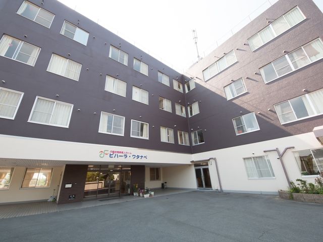清潔感のある施設の外観 外観 広々とした出入口が迎える、落ち着いた色合いの建物です。安心して勤務をスタートできる環境が整っています。