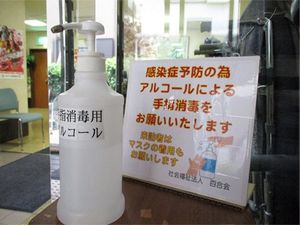 手指消毒の案内があるエントランス  