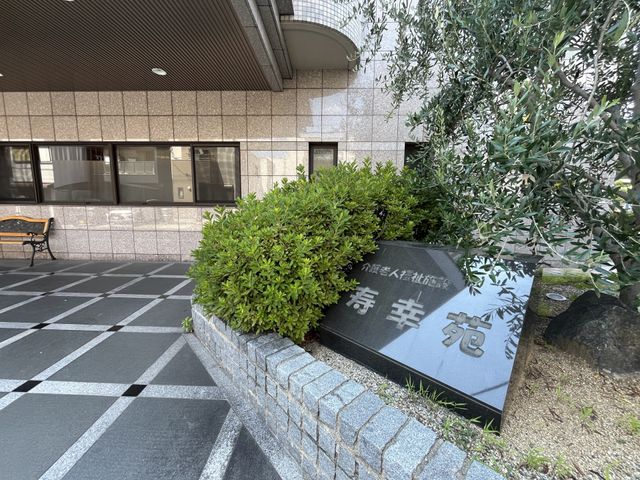 看板と庭 外観 施設の正面には整然とした庭があり、訪問者を迎える落ち着いた雰囲気が感じられます。