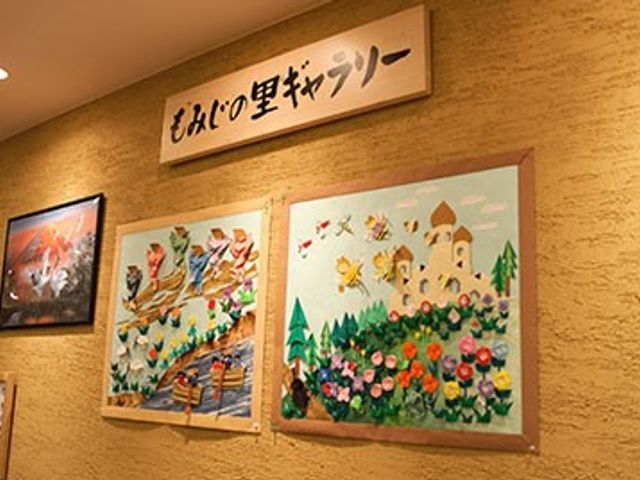 壁に飾られた絵の廊下 廊下 アート作品が飾られた廊下は、施設内のクリエイティブな雰囲気を高めています。