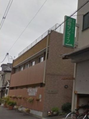 緑の看板が目立つ建物外観