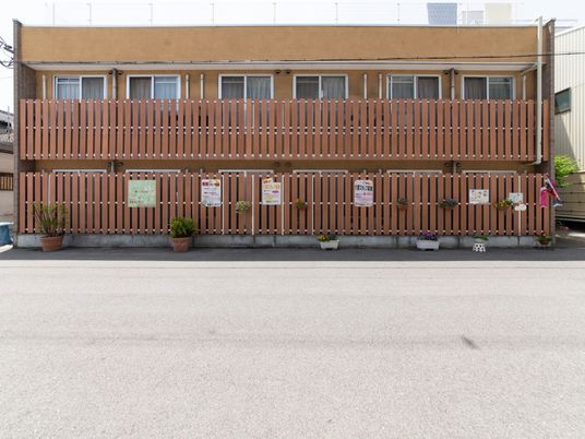 茶色の柵と看板の施設外観