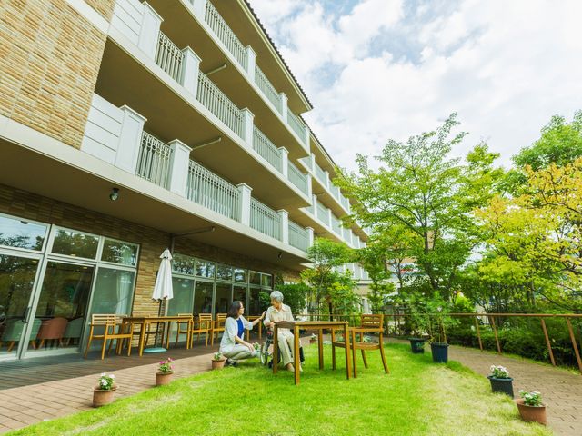 穏やかな時間を楽しむ庭 庭 広々とした緑に囲まれた空間で、入居者同士がリラックスして交流する様子を見られます。