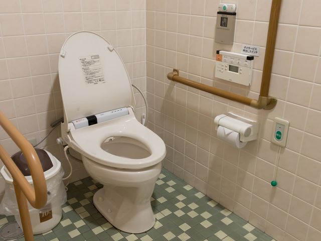 バリアフリー対応トイレ トイレ 安全な支えがある清潔なトイレで、利用者の快適さが保たれています。手すり付きでサポートが必要な方にも配慮された設計です。