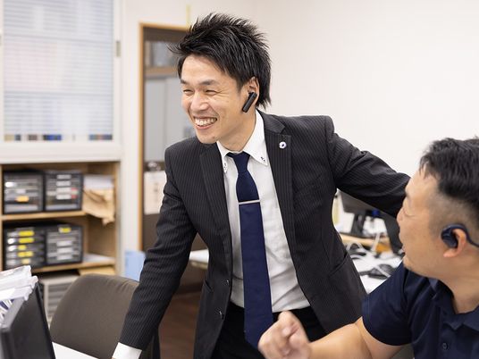 笑顔で話すスタッフ事務室  