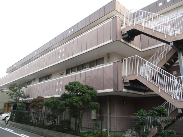 外階段のある建物外観 外観   白い外階段が目を引く、落ち着いた色合いの建物です。周囲には植栽があり、明るく整った印象です。