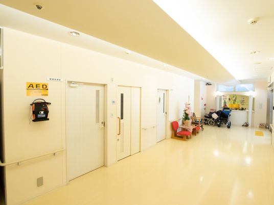 玄関から居室まで、フラットな床が続いている。十分な広いスペースが確保された廊下である。AEDも設置している。