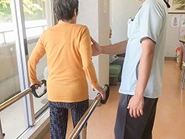 自然光の入る廊下 廊下 窓から自然光が差し込む明るい廊下で、サポートを受けながらの歩行訓練が行われています。