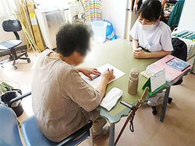 話し合うスタッフ スタッフイメージ 介護スタッフが入居者と親身に話し合う様子です。和やかな雰囲気でコミュニケーションを大切にしています。