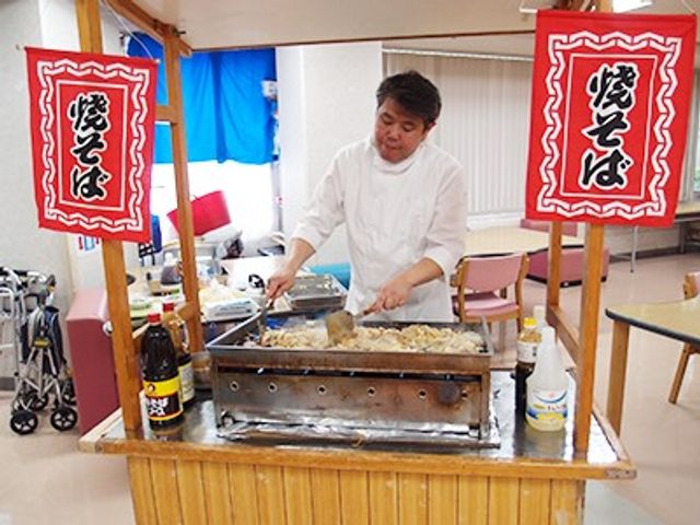 調理中の男性がいる空間 多目的室   男性が焼きそばを調理している風景です。イベント時などに賑やかに利用されるスペースです。