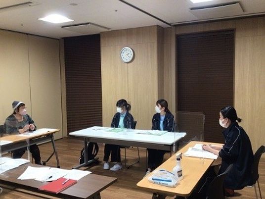 会議室で話す職員と利用者