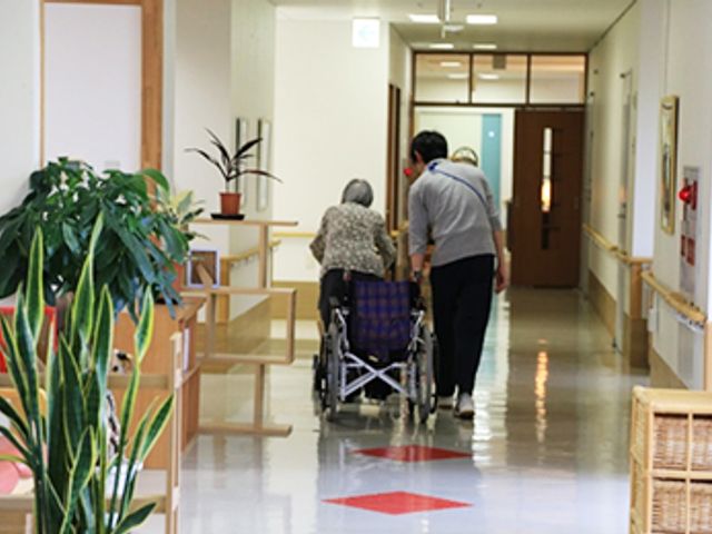 車椅子利用者が進む廊下 廊下 明るい廊下では、車椅子の方も安心して移動できるようになっています。温かみのある空間です。
