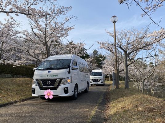 送迎車と桜並木の外観  