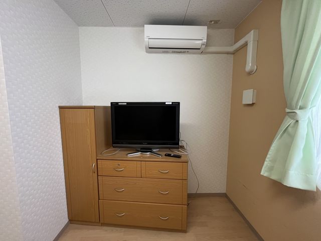 家具とテレビの居室 居室 シンプルな配置の居室で、家具やテレビが整然と並んでいます。静かに過ごせる環境です。