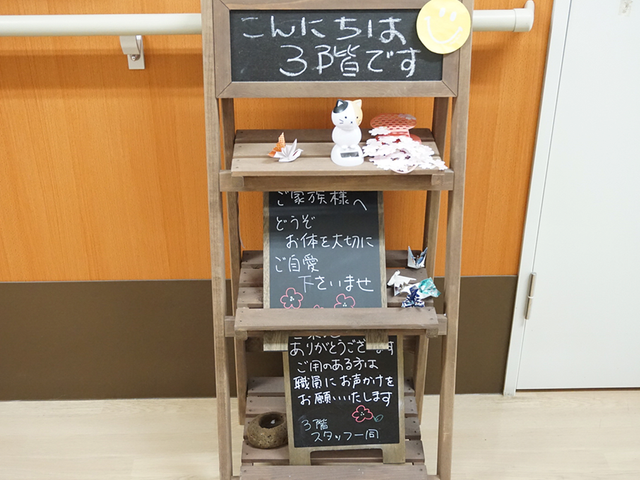 案内板がある廊下 廊下 階ごとの特徴を伝える案内板です。手作りの飾りが配置され、温かみを感じさせます。