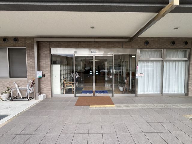 ガラス扉のエントランス エントランス 開放的で光が差し込む入り口は、来訪者を温かく迎える雰囲気があります。雨の日でも快適に入れます。