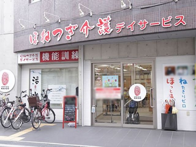 入り口の外観 看板 自転車が並ぶ入り口は、通勤に便利な環境です。訪問者を温かく迎える雰囲気があります。