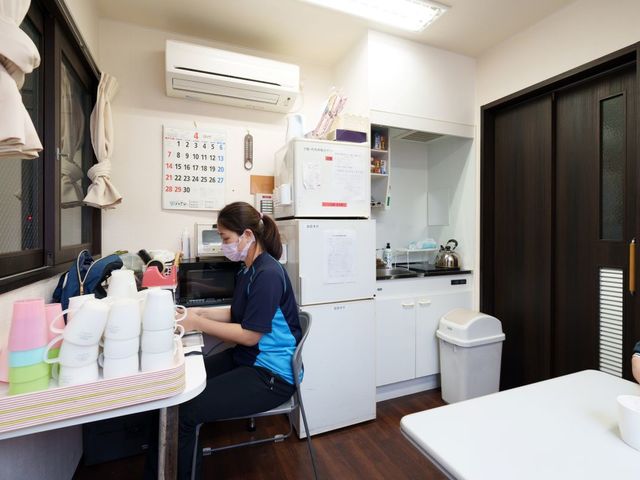 スタッフ休憩室 休憩室 カウンターに向かうスタッフがいる落ち着いた空間です。作業の合間にリラックスするのに最適です。