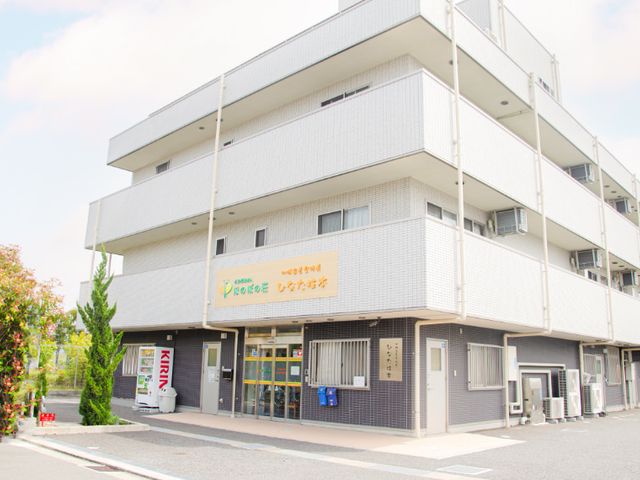 施設外観の建物 外観 青空の下に立つ、多層構造の施設です。広々とした設計で、訪れる人々を温かく迎えます。