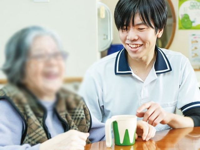 笑顔のスタッフと利用者がいる部屋 居室 笑顔のスタッフが利用者と親しげに会話を楽しめる温かな雰囲気の場所です。