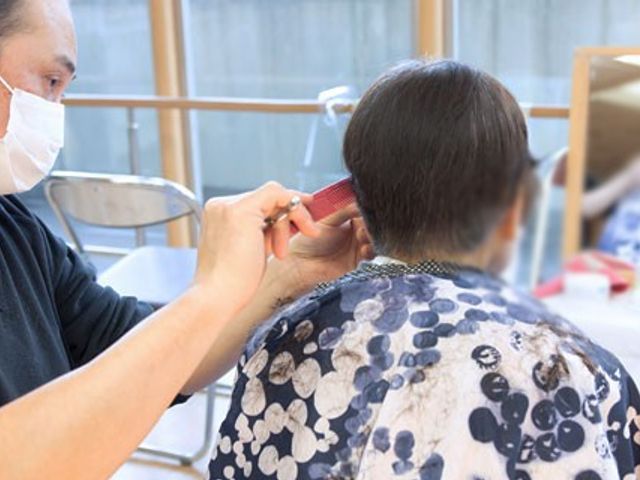 ヘアカットの場面 理美容室 明るい空間で、理美容サービスを受けられます。スタッフが丁寧に対応しています。