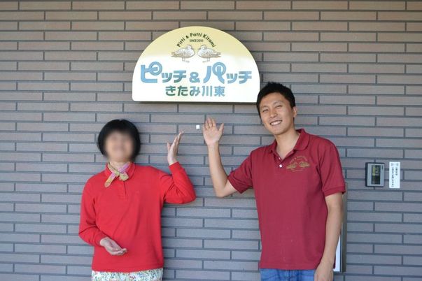 施設の看板前の様子