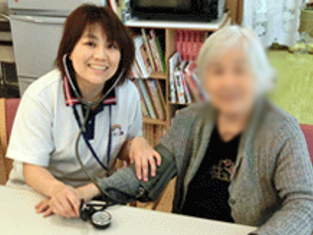 看護師との対話 スタッフイメージ 居心地の良い空間で、高齢者の健康チェックが丁寧に行われています。優しいスタッフがお手伝いします。