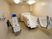 サムネイル 機械浴槽と介護用の椅子が桃色の浴室内に置かれている。また、壁には体を洗う布とシャワーが備えつけられている。