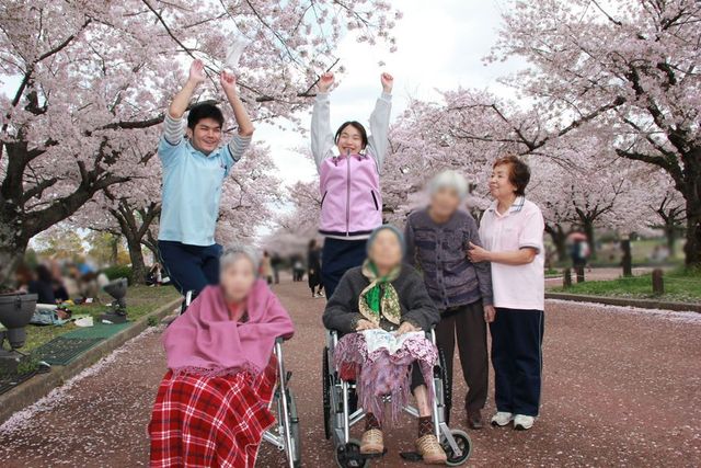 桜並木を背景にした施設利用者との交流