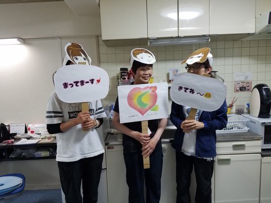 調理場で手作り掲示を持つスタッフ  