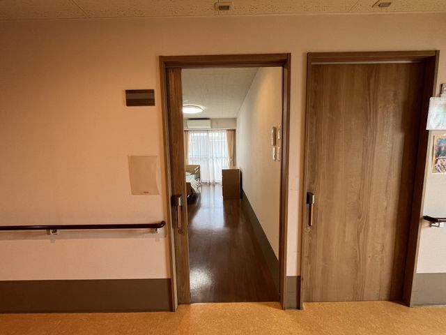 居室に面する廊下 居室 温かみのある居室が覗けます。手すりが設置された安全な廊下です。