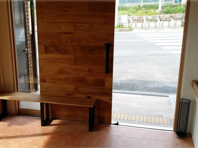 外に通じる扉 エントランス 広々としたエントランスは、自然光が差し込み、明るい雰囲気を作り出しています。ベンチがあり、休める場所もあります。