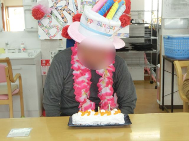 誕生日を祝う様子のエントランス エントランス 楽しい雰囲気の中、誕生日を祝う姿が見られます。スタッフと利用者が笑顔で交流しています。