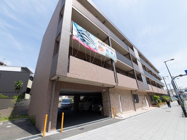 現代的な建物のエントランス 外観 洗練されたデザインの建物前には広々とした道があり、駐車場へのアクセスも良好です。こうした明るく開放的な環境は、職場としても非常に魅力的です。