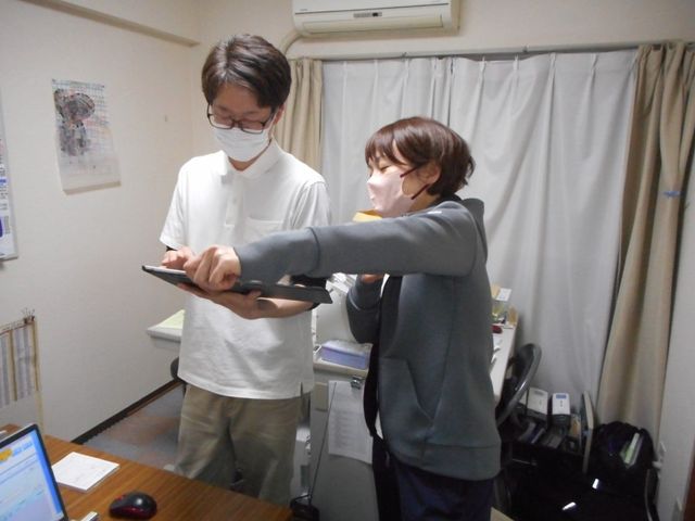 スタッフが相談する居室 居室 職員が日々の業務について話し合う様子です。意見交換をしやすい環境が整っています。