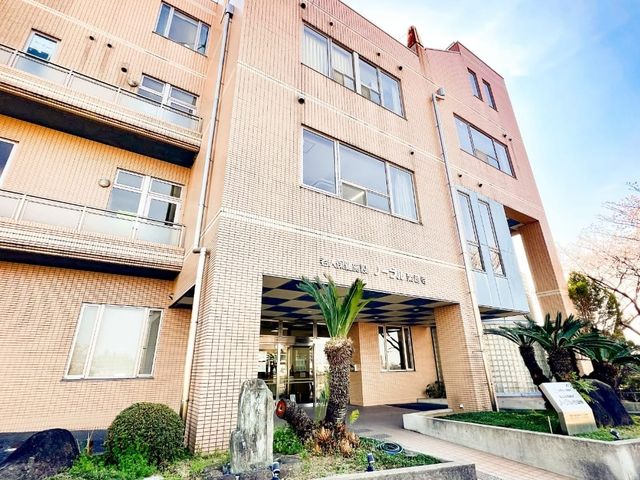 庭のある建物外観 外観 明るく開放的な入口が特徴の建物で、緑に囲まれています。温かみのある外観は訪れる人を迎え入れます。