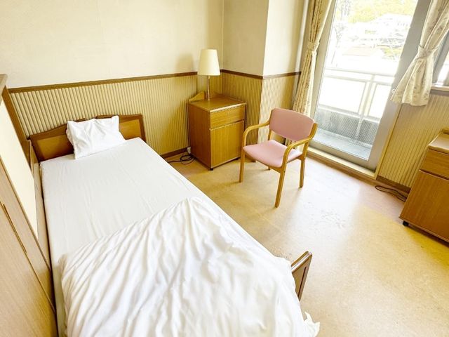 ベッドのある居室 居室 ベッドと椅子が置かれた明るい空間です。窓からは自然光が差し込み、爽やかさを感じられます。