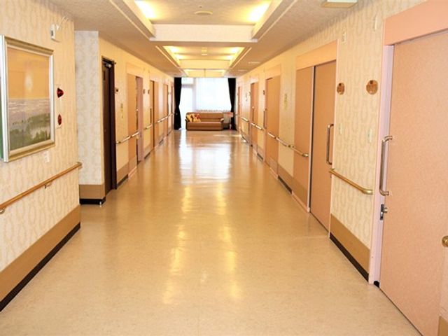 明るい廊下 廊下   手すりが両側に設けられた、まっすぐ伸びる明るい廊下です。奥まで見通しがよく、移動のしやすさが伝わります。