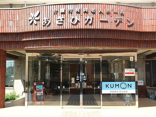 木目調の看板がある玄関外観