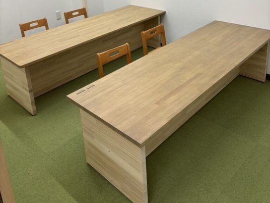 木目調の長机が並ぶ多目的室  