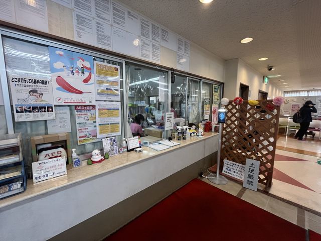落ち着いた受付の前 フロント 多くの情報が整理されて掲示された受付フロントです。落ち着いた雰囲気で、訪れる方を温かく迎えます。