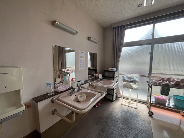 洗面と物品のある部屋 洗面台 広々とした空間で、自然光が差し込む明るい洗面エリアです。お手入れや準備が快適に行えます。