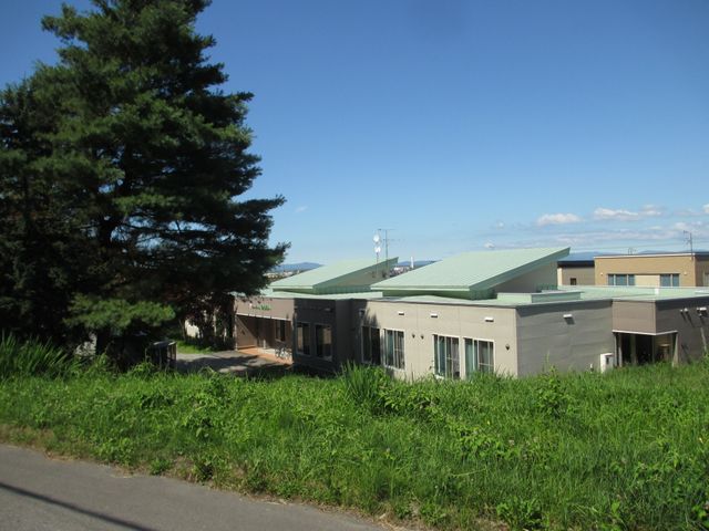 緑に囲まれた建物の外観  